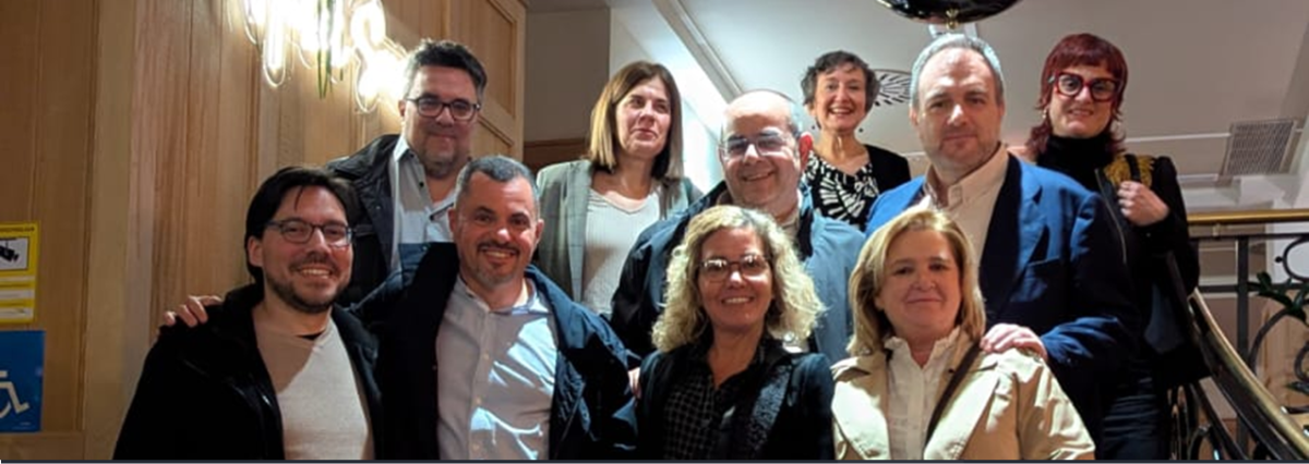 10 personas en varias filas a diferentes alturas sonriendo de frente